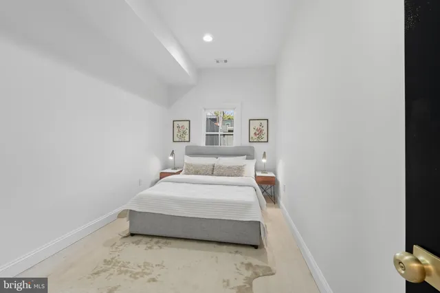 a spacious bedroom with a bed and a night stand