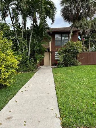 a backyard of a house with plants and large trees