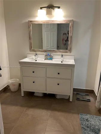 a bathroom with a double vanity sink and a mirror