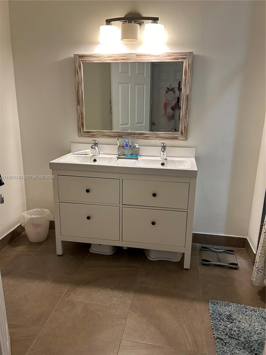 6619 Southwest 116th Place, Unit B7 Miami, FL 33173 - Photo 17 of 27 a bathroom with a double vanity sink and a mirror