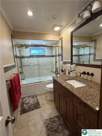 a bathroom with a granite countertop sink a toilet and bathtub