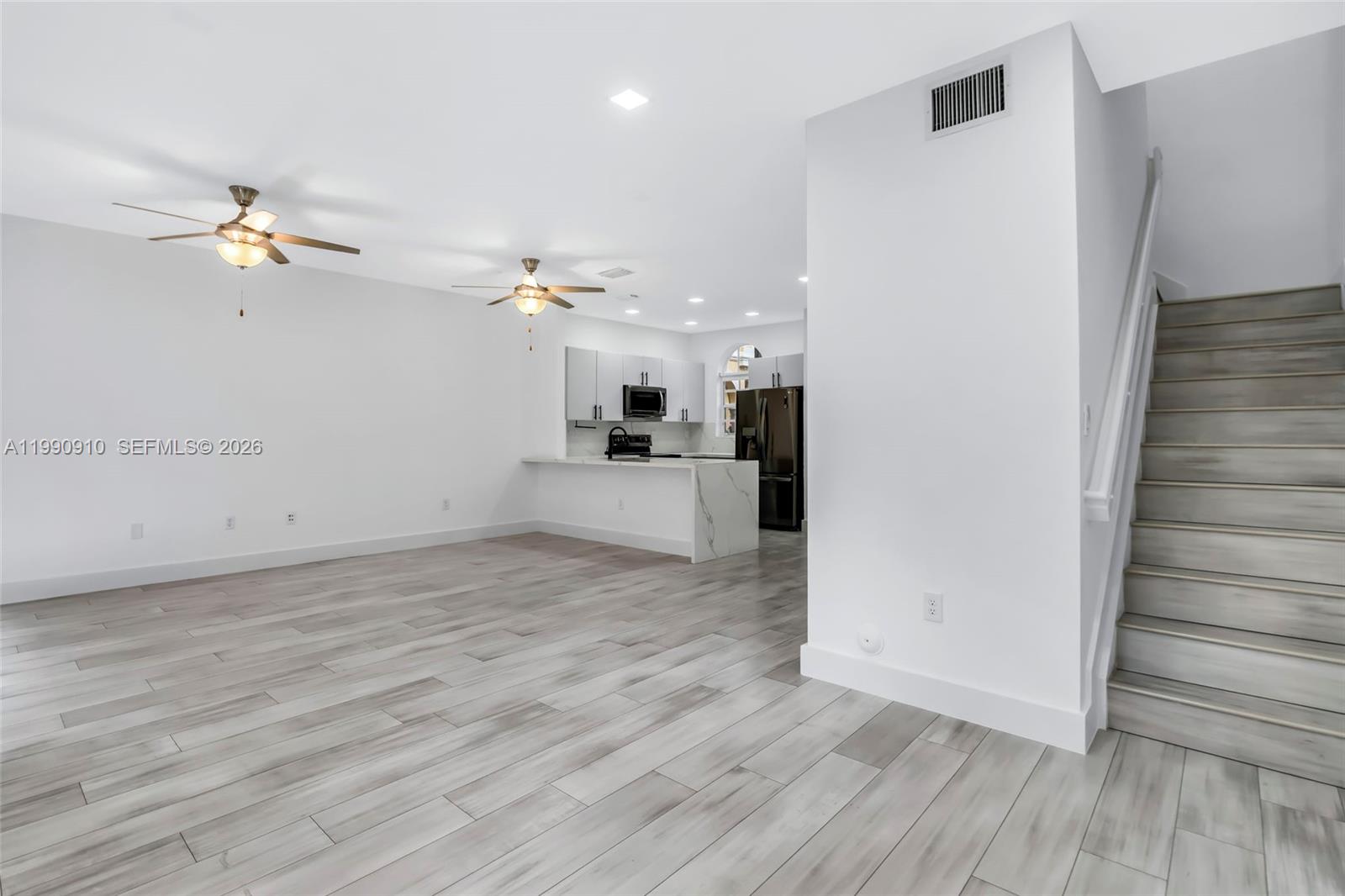 4977 Southwest 135th Way Miramar, FL 33027 - Photo 11 of 28 a view of a room with wooden floor and ceiling fan