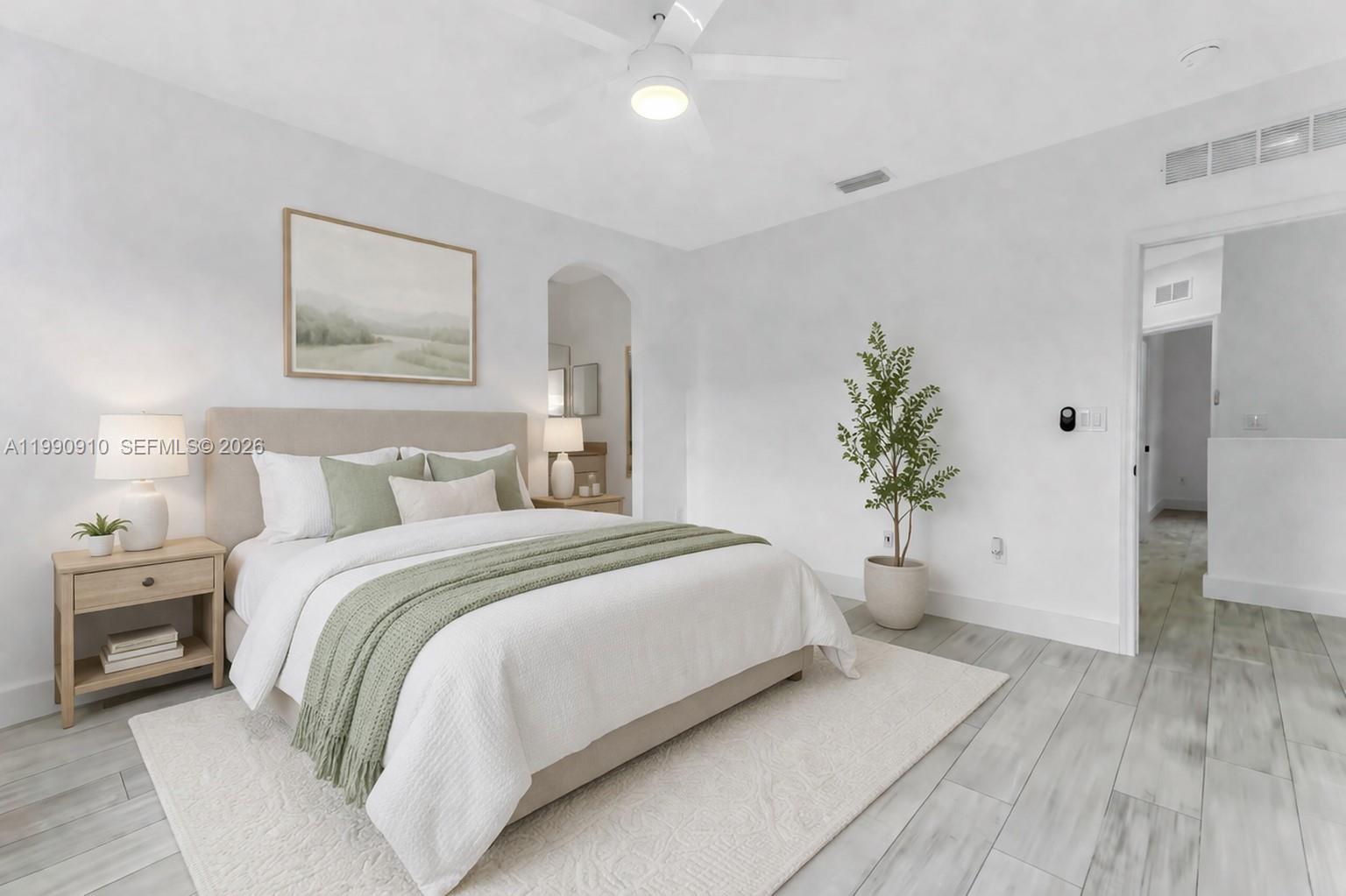 4977 Southwest 135th Way Miramar, FL 33027 - Photo 13 of 28 a spacious bedroom with a bed and a potted plant