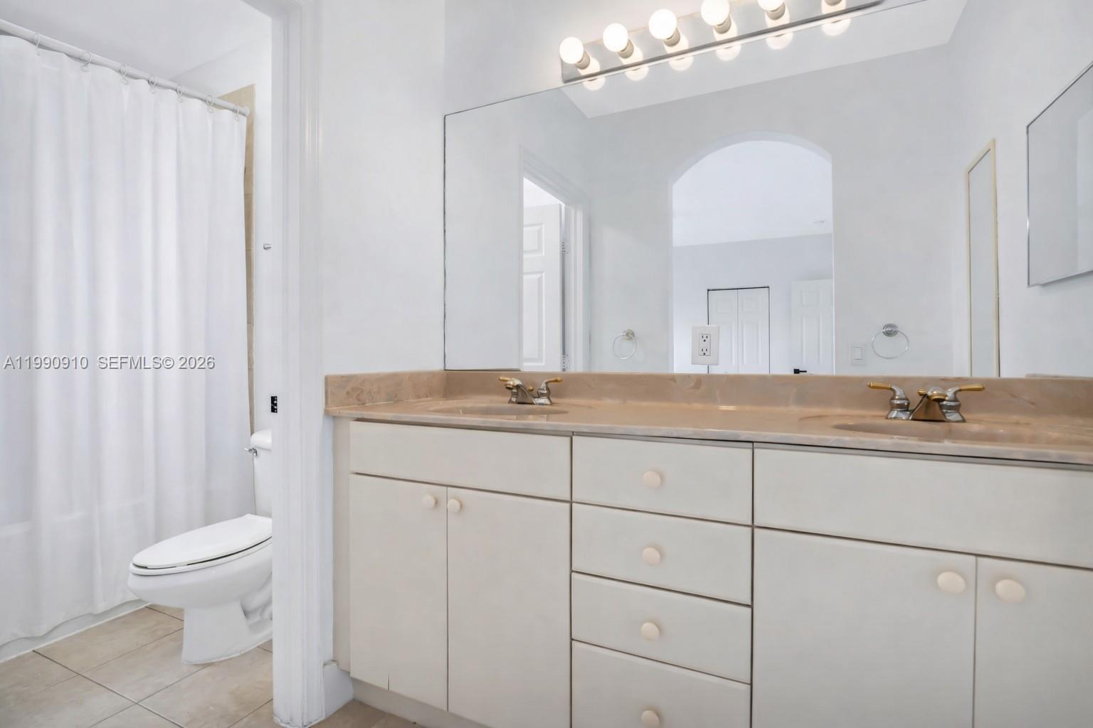 4977 Southwest 135th Way Miramar, FL 33027 - Photo 15 of 28 a bathroom with a granite countertop sink a toilet and a mirror