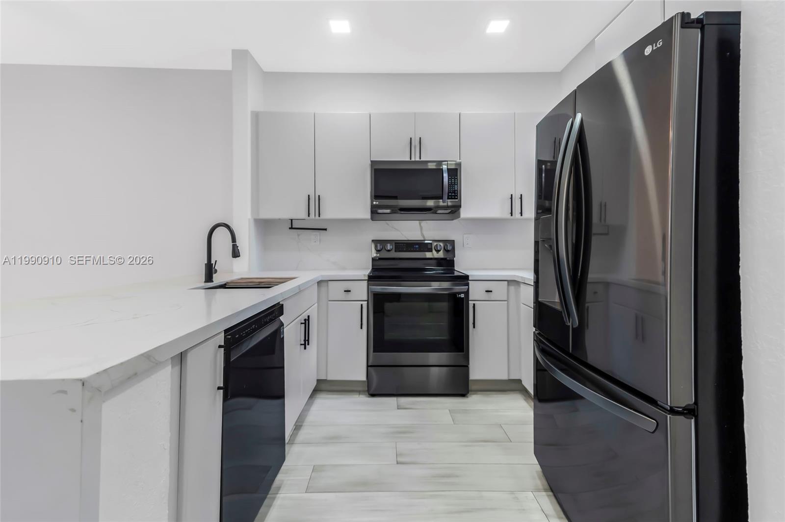 4977 Southwest 135th Way Miramar, FL 33027 - Photo 4 of 28 a kitchen with stainless steel appliances a refrigerator stove and microwave