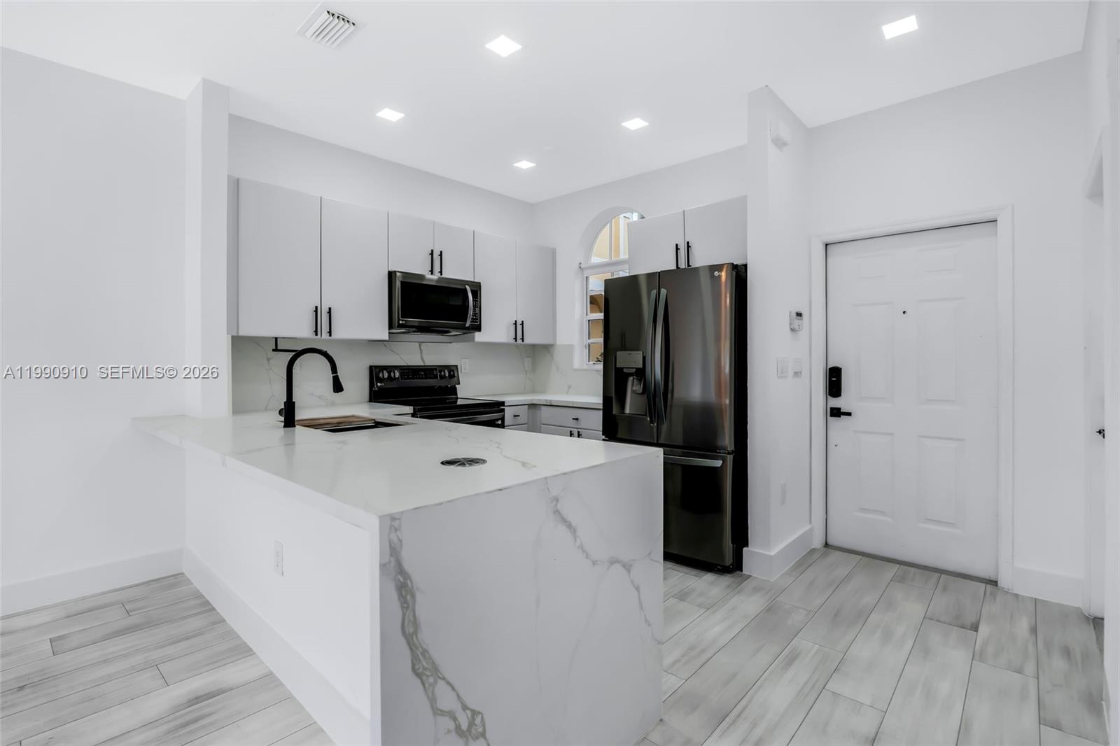 4977 Southwest 135th Way Miramar, FL 33027 - Photo 5 of 28 a kitchen with a refrigerator a stove top oven a sink and dishwasher