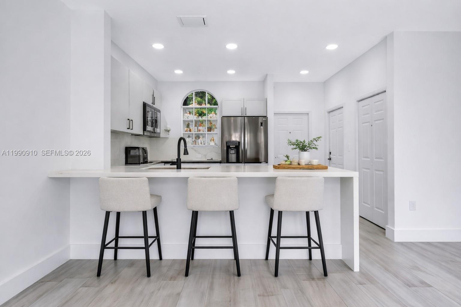 4977 Southwest 135th Way Miramar, FL 33027 - Photo 6 of 28 a kitchen with kitchen island stainless steel appliances a dining table chairs sink and cabinets