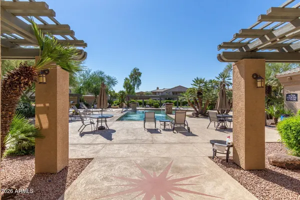 a view of a patio with a table and chairs under an umbrella