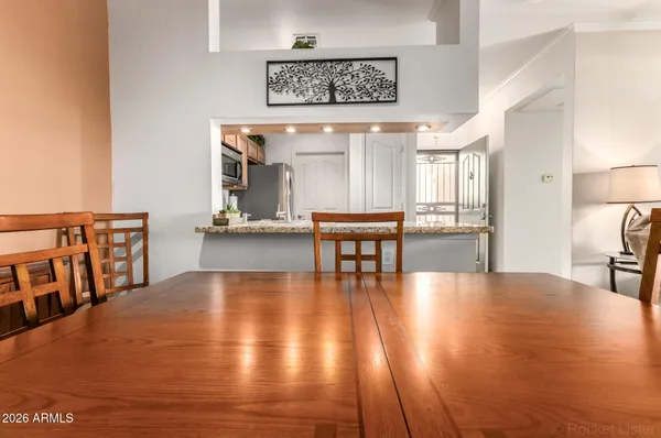a view of a kitchen with stainless steel appliances granite countertop a refrigerator and a stove top oven
