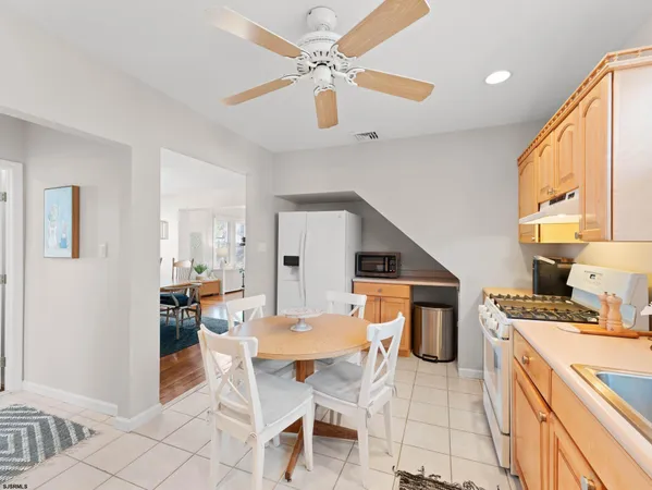 a kitchen with stainless steel appliances granite countertop a stove a sink dishwasher a dining table and chairs with wooden floor