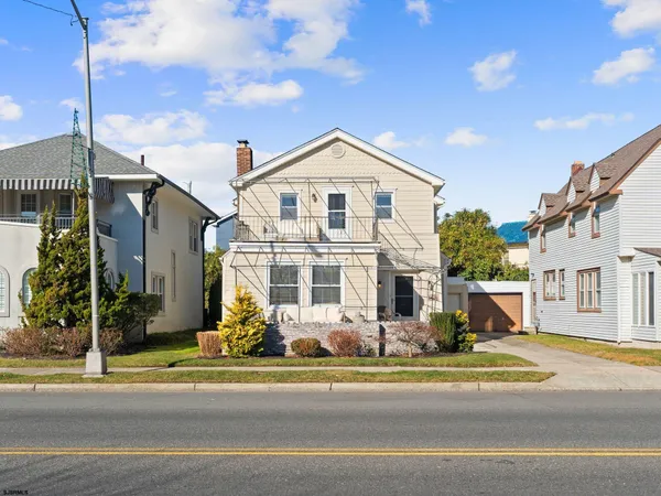 a view of a white house with a clock tower in the middle
