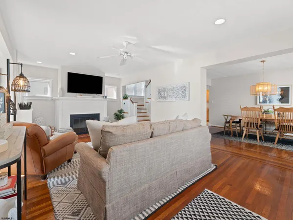 a living room with furniture a flat screen tv and kitchen view