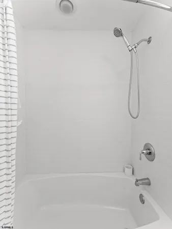 a bathroom with a bath tub with a shower