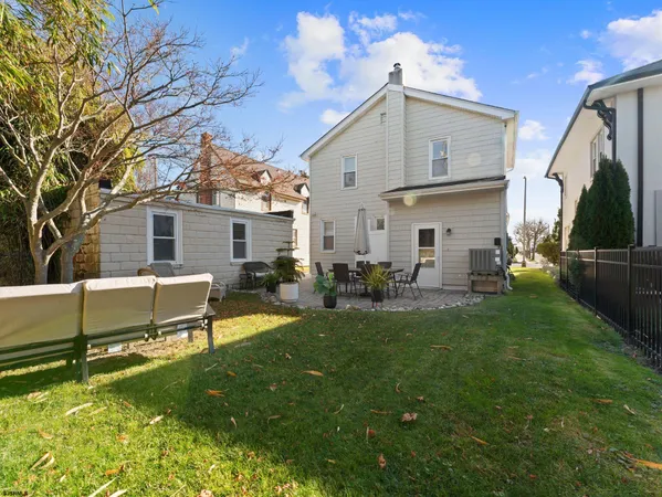 a view of a house with backyard and sitting area