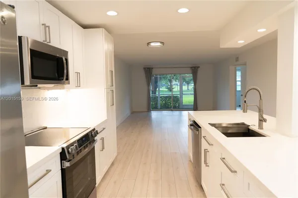 a kitchen with granite countertop a sink and a stove top oven