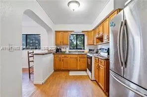 a kitchen with stainless steel appliances granite countertop a refrigerator a sink and a stove