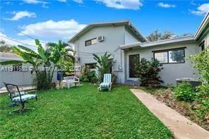 a view of a chair and table in backyard of the house
