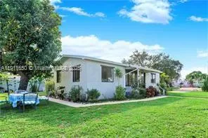 a view of a house with backyard sitting area and garden