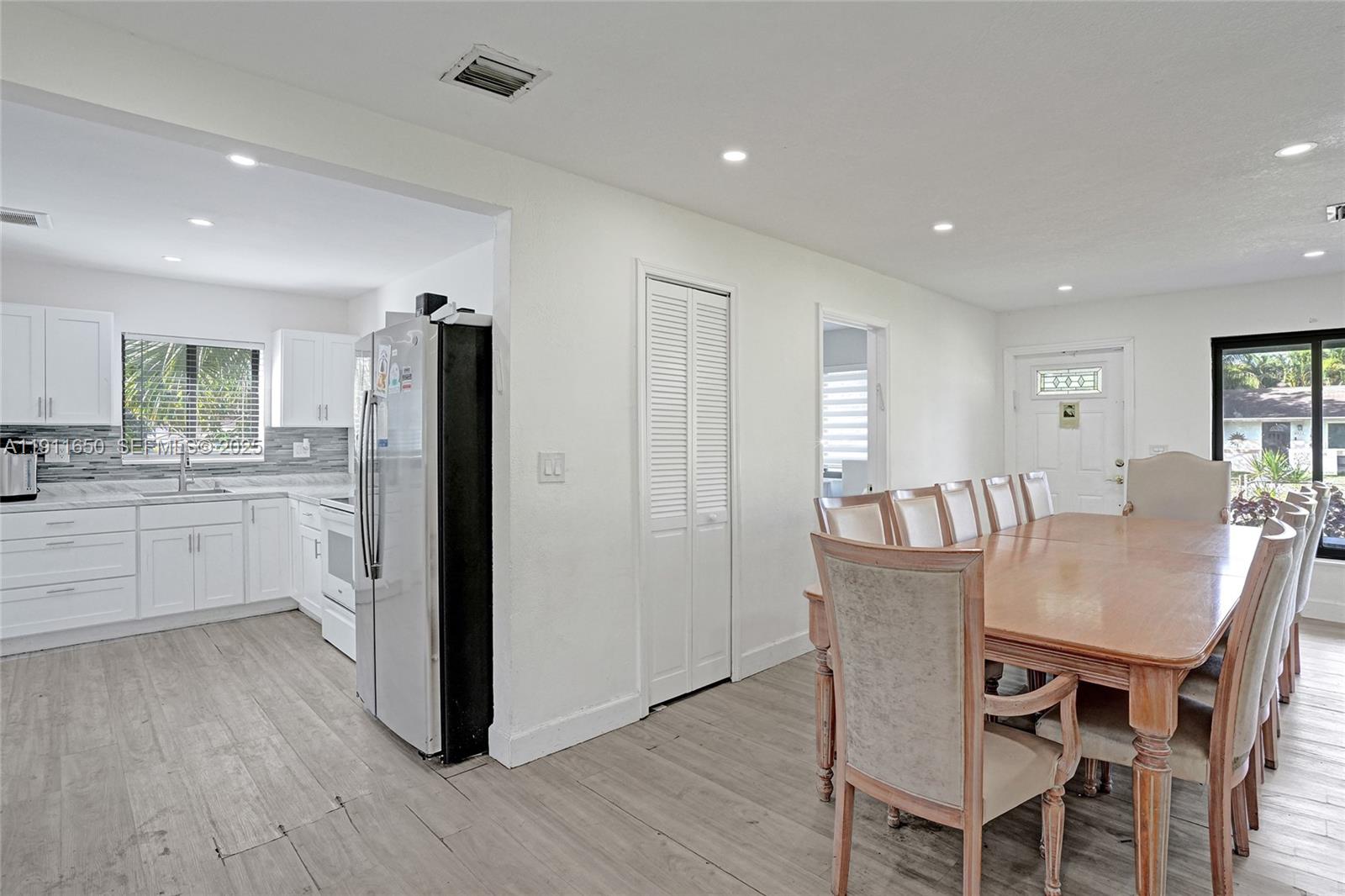 6470 McClellan Street Hollywood, FL 33024 - Photo 63 of 74 a kitchen with stainless steel appliances granite countertop a dining table chairs refrigerator sink and cabinets