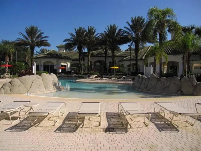 a view of a house with swimming pool and sitting area