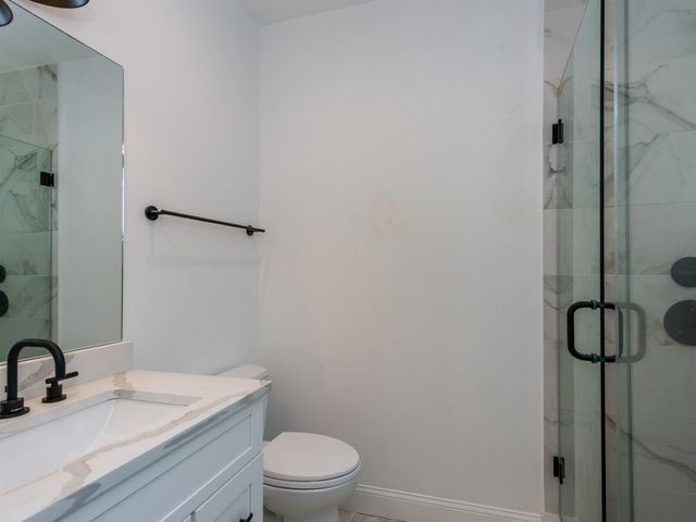 a bathroom with a granite countertop sink toilet and shower