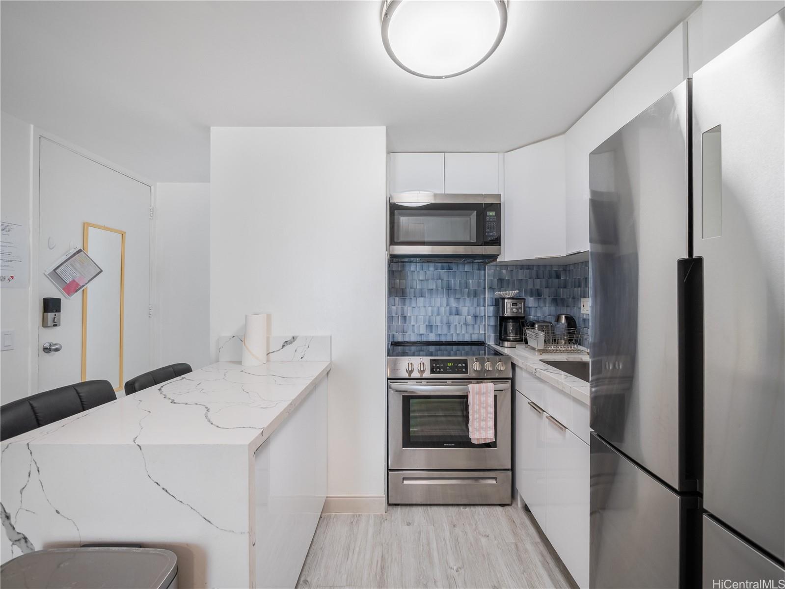 2572 Lemon Road, Unit 610 Honolulu, HI 96815 - Photo 13 of 24 a kitchen with a stove a sink and a refrigerator