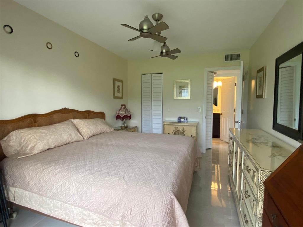 321 Durham, Unit 321 Deerfield Beach, FL 33442 - Photo 11 of 18 a bedroom with a bed and ceiling chandelier