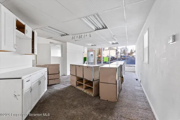 a view of a livingroom with wooden floor and a ceiling fan
