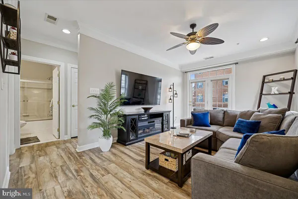 a living room with furniture a ceiling fan and a window