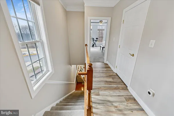 a view of a hallway with wooden floor and staircase