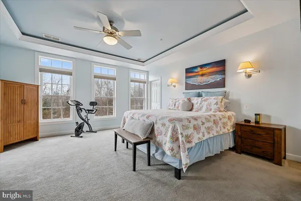 a bedroom with a bed a couch and a ceiling fan
