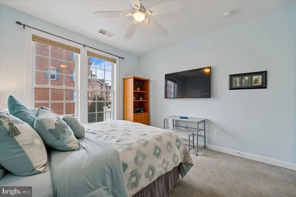 a bedroom with a bed a flat screen tv and a chandelier