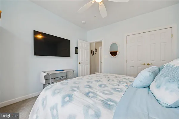 a bedroom with a bed and a lamp on dresser