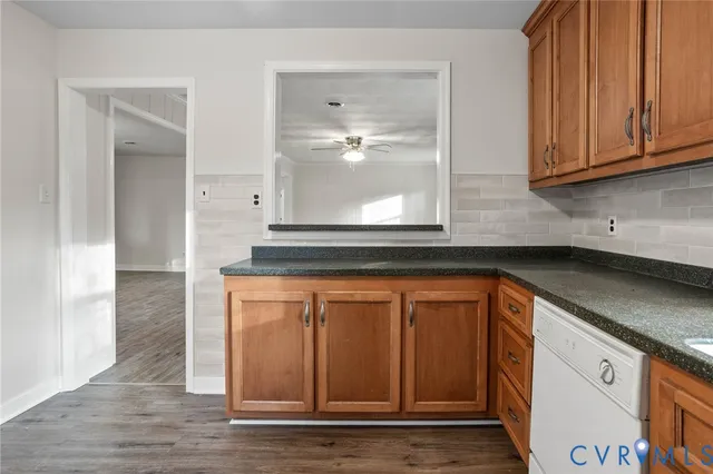 a kitchen with stainless steel appliances granite countertop a sink and cabinets with wooden floor