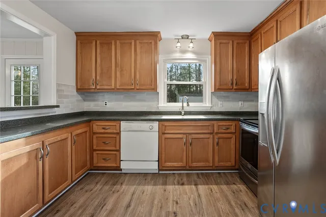 a kitchen with stainless steel appliances granite countertop a stove a sink and a refrigerator