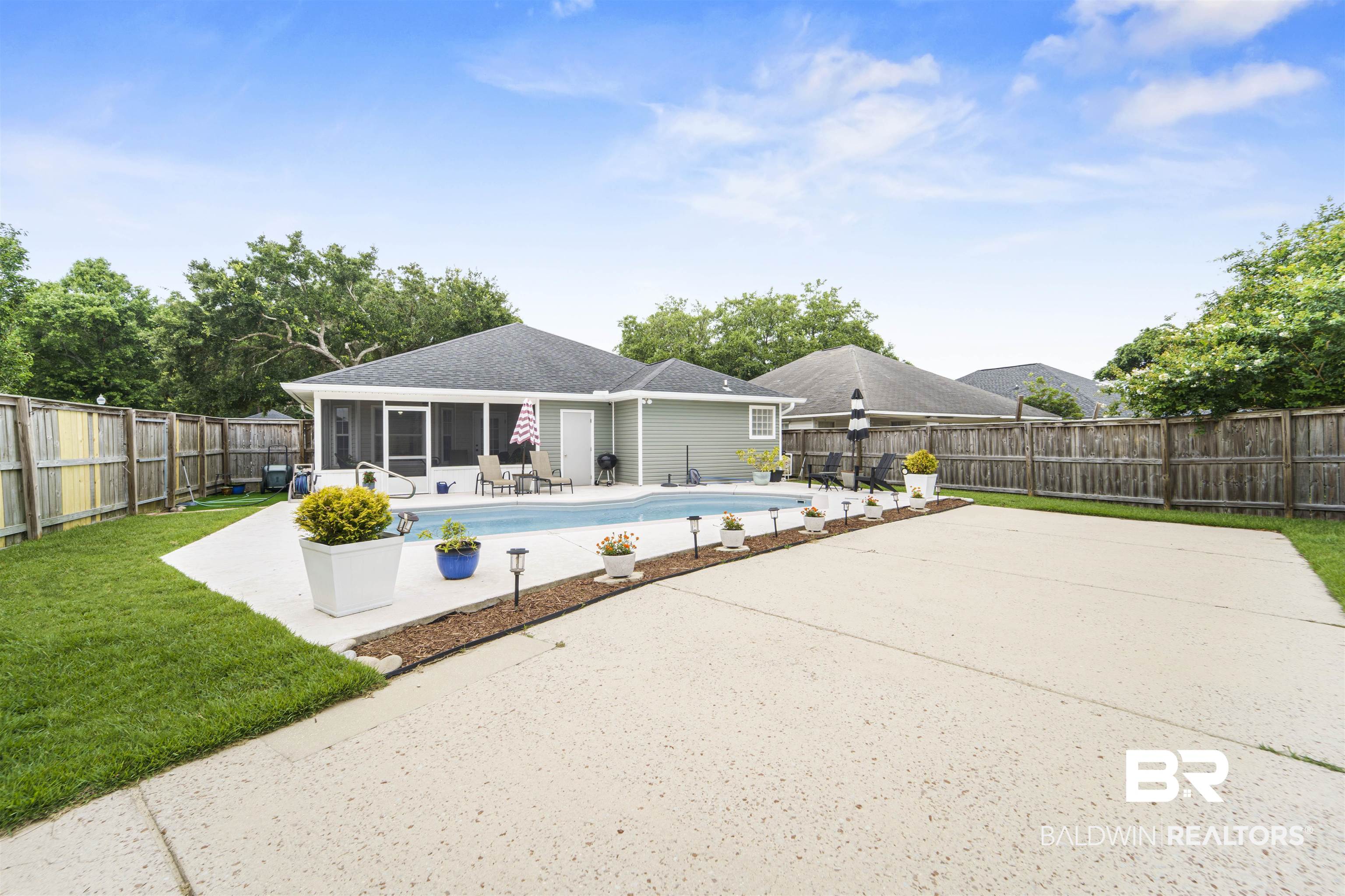 4620 Pine Boulevard Orange Beach, AL 36561 - Photo 28 of 49 View of pool featuring a sunroom, a patio area, and a fenced backyard