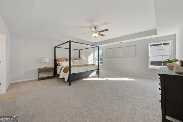 a bedroom with a bed a chandelier and a window
