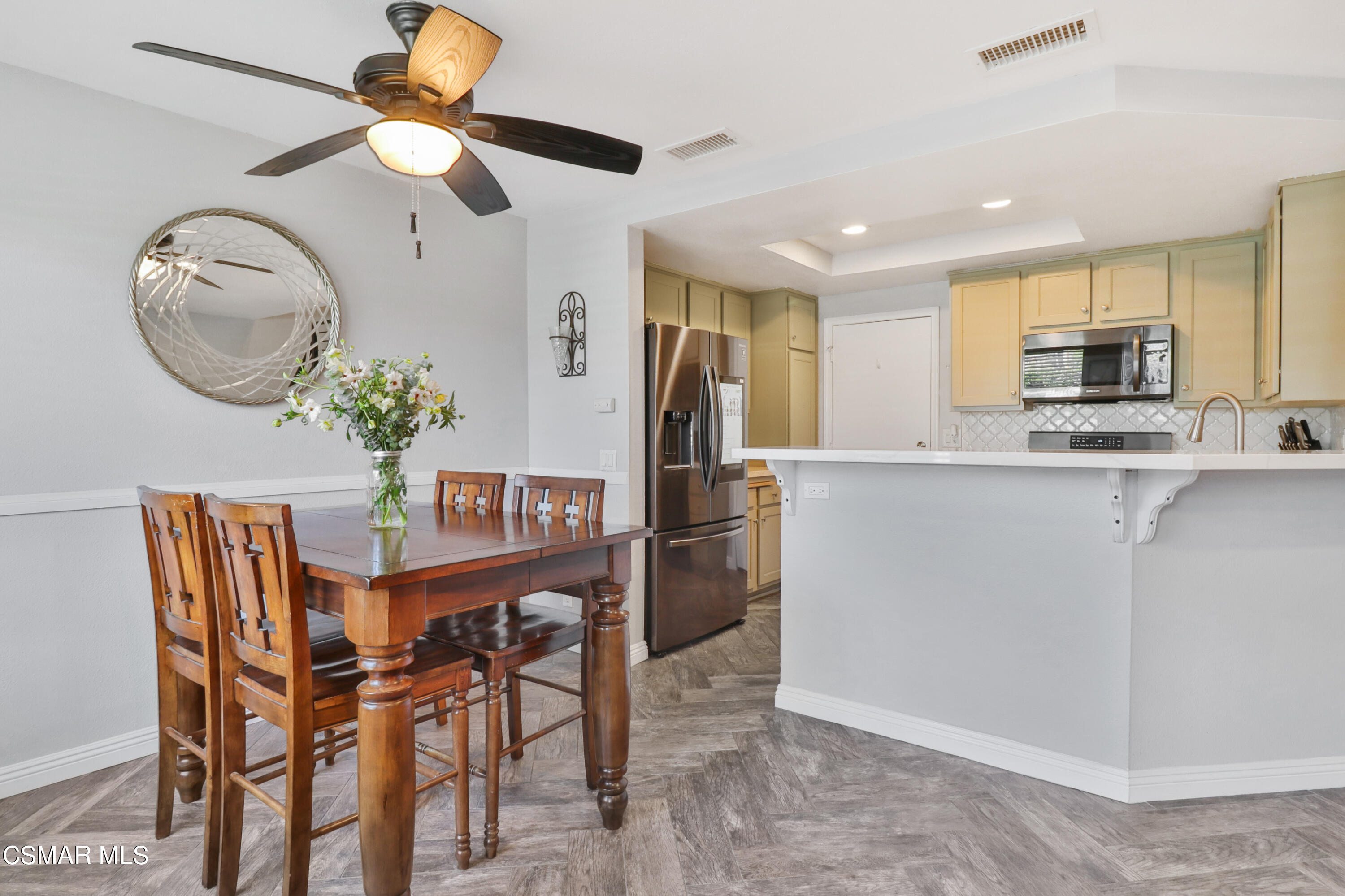 3974 Cochran Street, Unit 80 Simi Valley, CA 93063 - Photo 10 of 33 a kitchen with stainless steel appliances kitchen island granite countertop a dining table chairs and a refrigerator