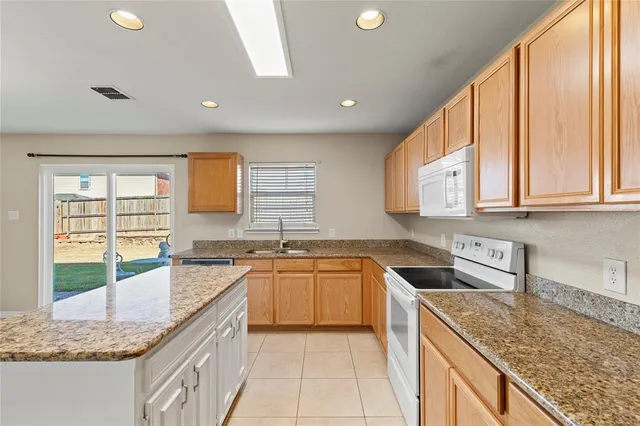 a kitchen with stainless steel appliances granite countertop sink stove and cabinets