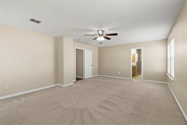 a view of an empty room with a chandelier fan