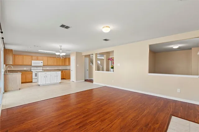 a view of a kitchen with wooden floor and windows