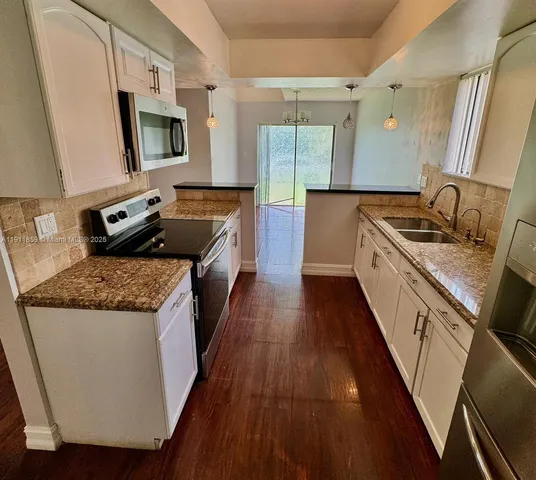 a kitchen with a stove a sink and a refrigerator