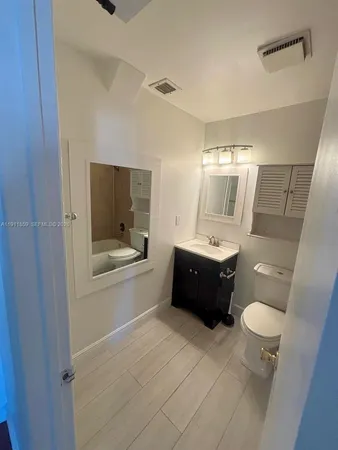 a bathroom with a bathtub shower sink and toilet
