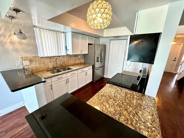 a kitchen with a stove a sink and a refrigerator