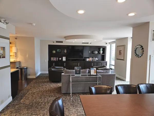 a living room with furniture a flat screen tv and a large window