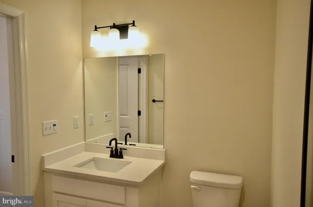 a bathroom with a sink a toilet and mirror