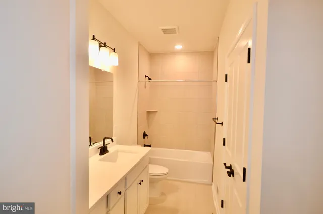 a bathroom with a tub shower and sink