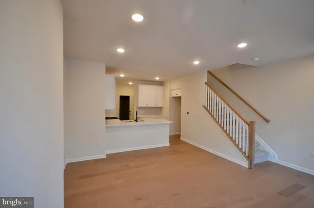 a view of a hallway with a living room and utility room