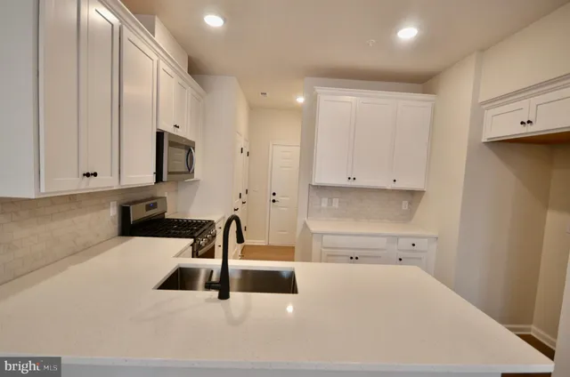 a kitchen with stainless steel appliances a sink a stove and a microwave