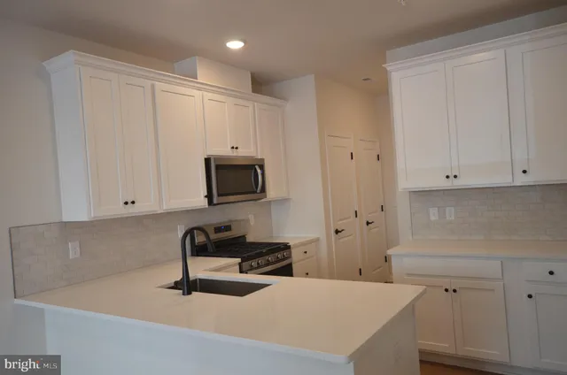 a kitchen with a sink stainless steel appliances and cabinets